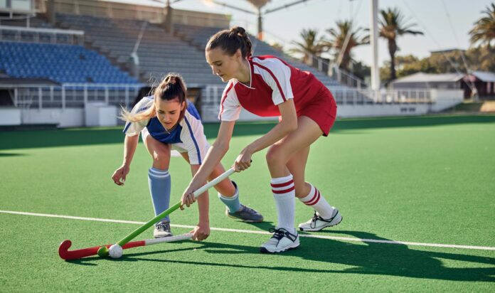 Sports fitness, field hockey game and women challenge for ball in stadium competition, club rival match or tournament contest Training exercise, workout and athlete battle action on arena turf pitch