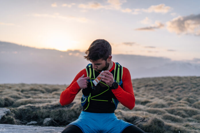 Male trail runner enjoys granola bar