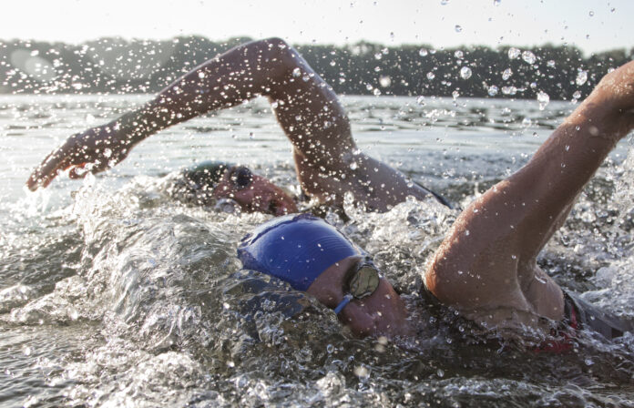 two triathletes swimming side by side